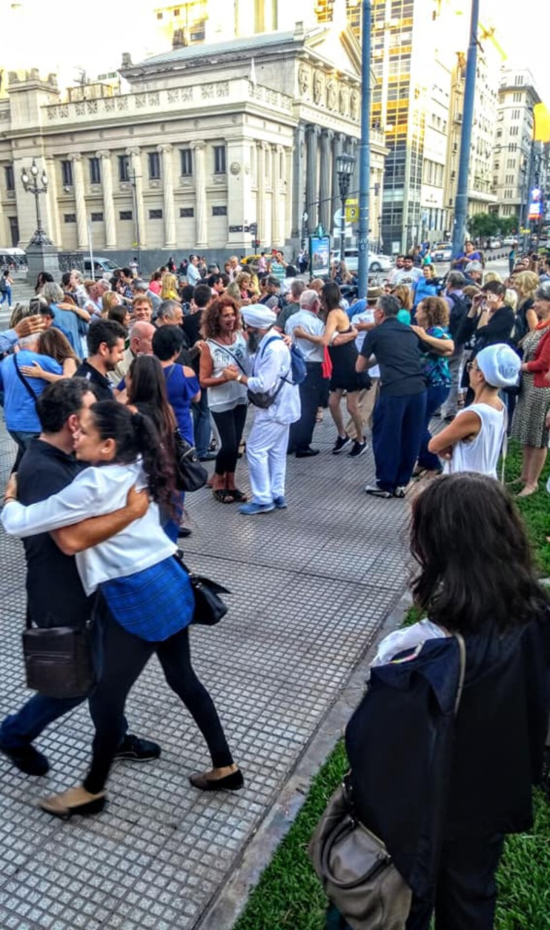 Tanzende Menschenmenge auf der Straße vor einem Gebäude, Buenos Aires, Argentinien.