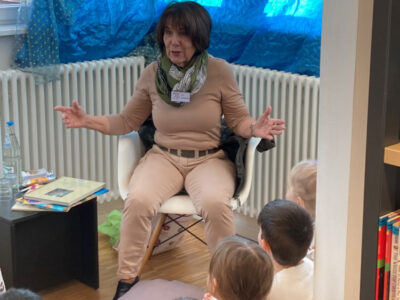 Frau erzählt Kindern eine Geschichte. Vorlese-Event, Bildung für Kinder.